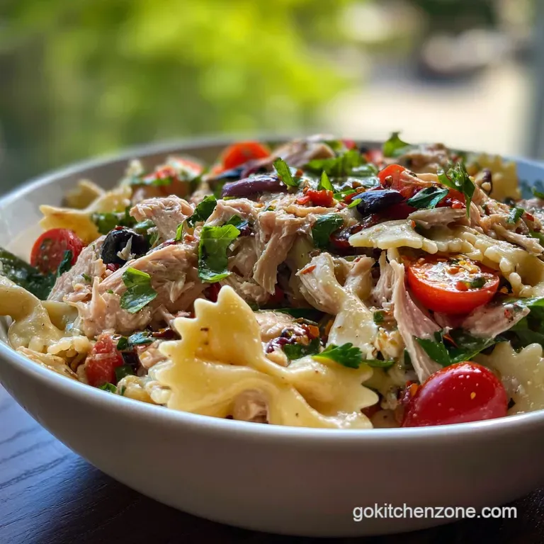 A vibrant plate of tuna pasta salad: creamy, light dressing clings to perfectly cooked pasta, accented with fresh herbs an...