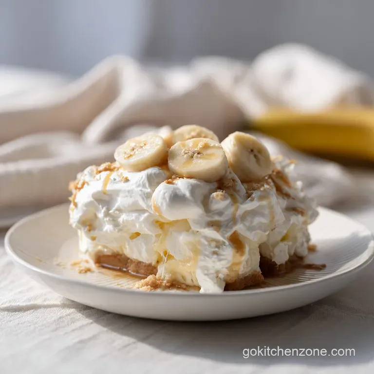 A generous scoop of creamy banana pudding, crowned with a fluffy toasted meringue, in a clear glass.